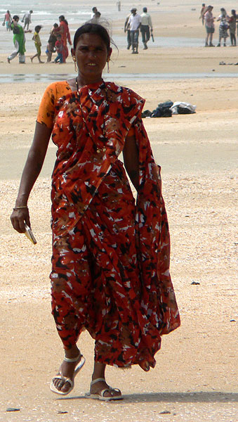 Barevně oblečená indka v sárí na pláži Goa